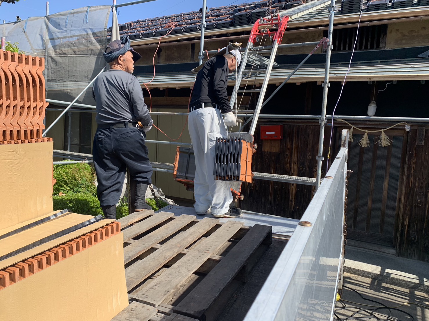 天秤棒で瓦を運ぶ様子