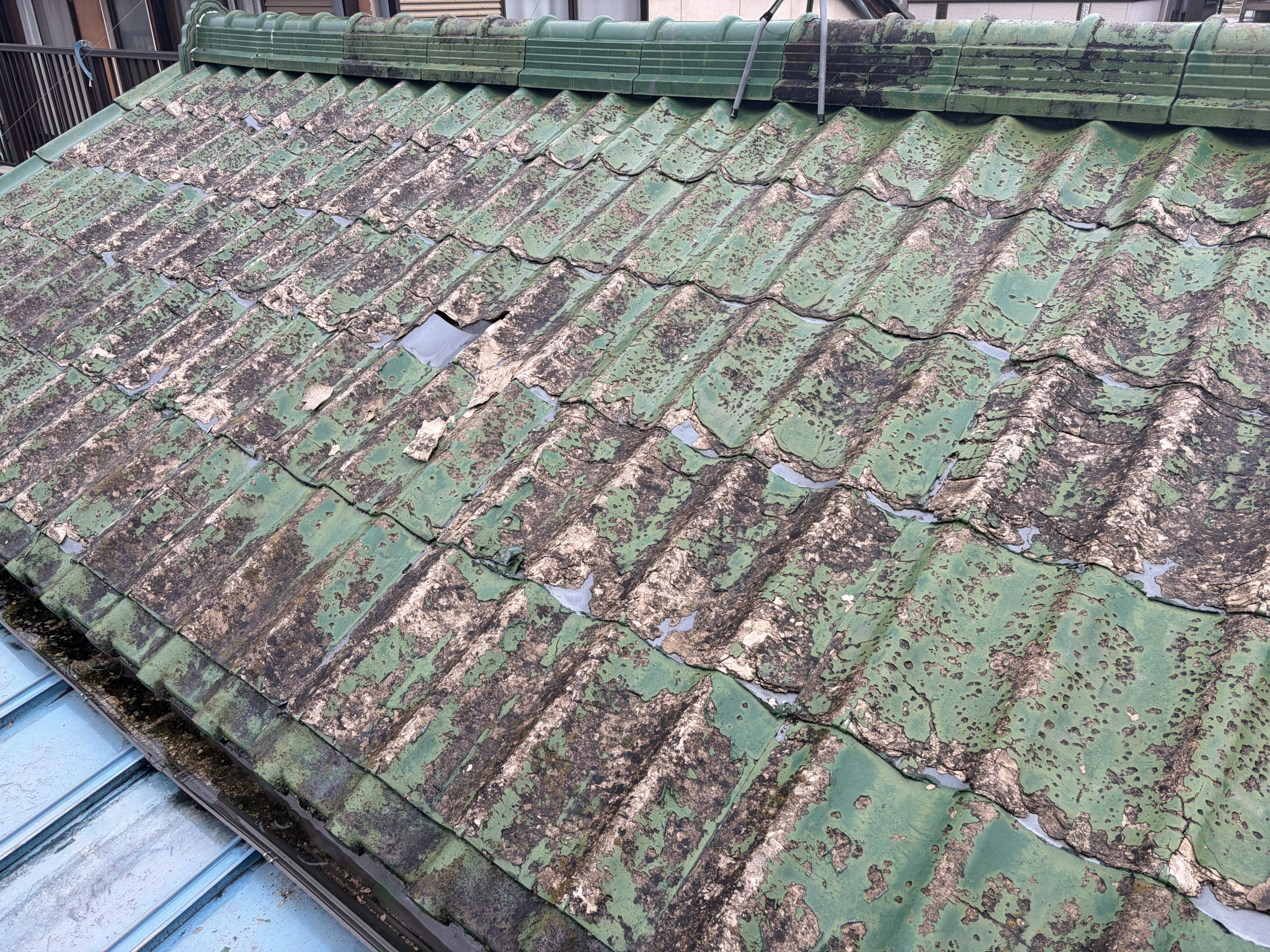 春日井市で雨漏り調査を行ったセキスイかわらUの屋根。屋根材の表面が激しく劣化し、所々に穴が開いている状態